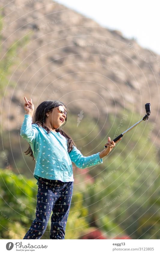 Little girl taking a picture with an action camera Lifestyle Joy Happy Leisure and hobbies Playing Vacation & Travel Child Camera Tool Technology Human being