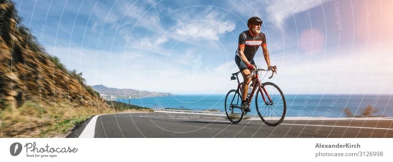 Mature Adult on a racing bike climbing the hill coastal road Vacation & Travel Summer Beach Sports Human being Nature Highway Fitness bicycle cycling sky