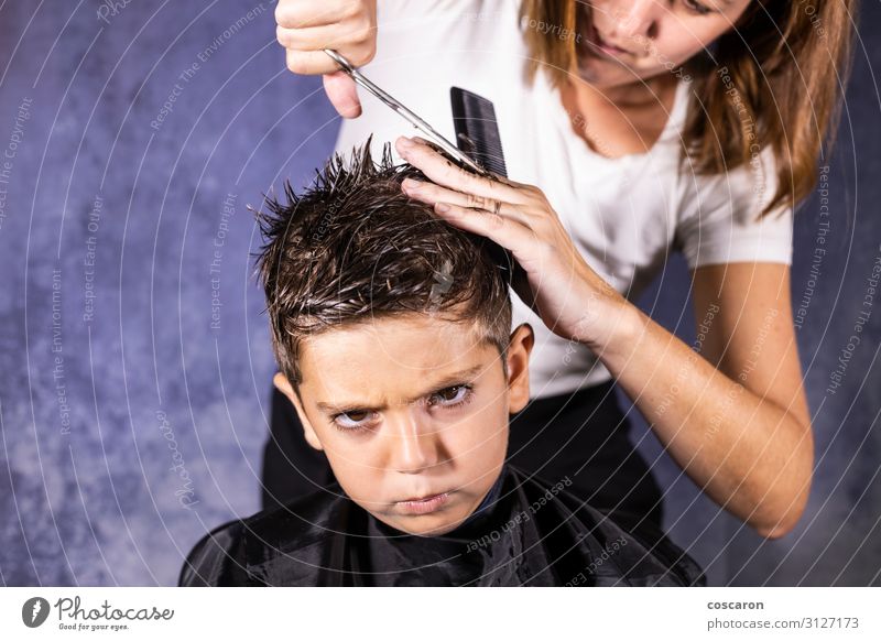 Beautiful boy getting a haircut with scissors Lifestyle Shopping Style Design Hair and hairstyles Face Child Profession Hairdresser Workplace Business Scissors