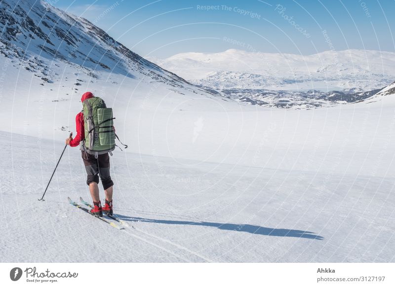 Skier with backpack in front of alpine mountain landscape Senses Calm Far-off places Winter vacation Winter sports Skiing 1 Human being Nature Beautiful weather