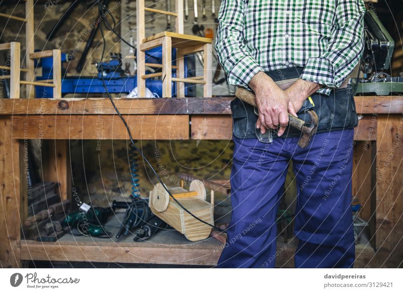 Unrecognizable carpenter holding a hammer Leisure and hobbies Chair Work and employment Profession Business Retirement Hammer Human being Man Adults Hand Old