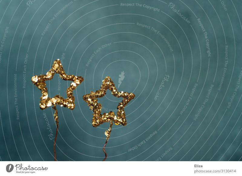 Two gold glittering stars against a blue background. Christmas, Advent, decoration. Decoration Christmas & Advent New Year's Eve Glittering Blue Gold Universe