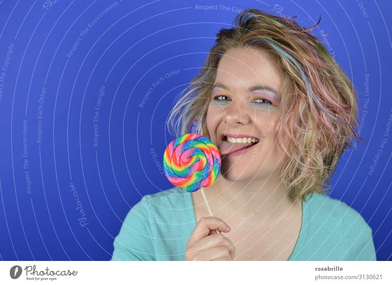 young blonde woman with coloured strands of hair biting into a giant lollipop Candy Joy Happy Beautiful Hair and hairstyles Make-up Contentment Carnival