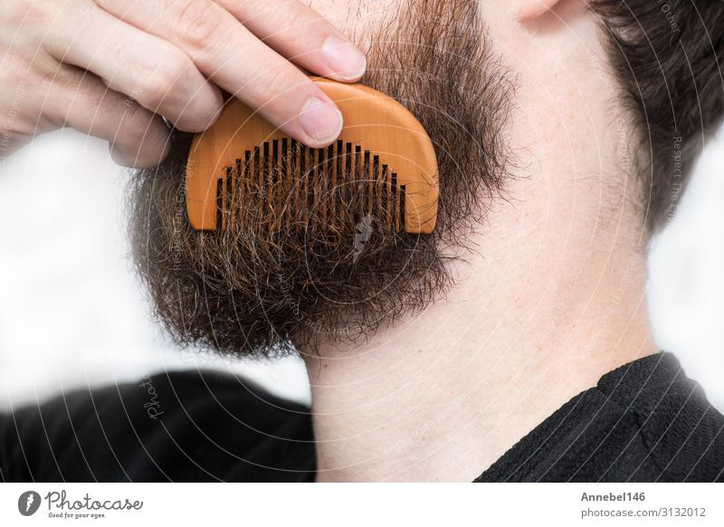 Closeup of a young man styling his long beard with a comb Lifestyle Style Hair and hairstyles Face Human being Masculine Man Adults Fashion Brunette Moustache