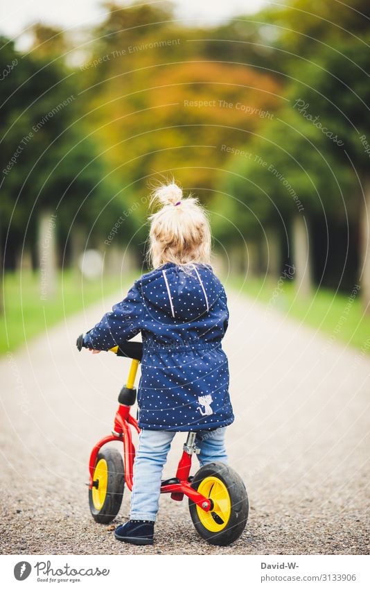 Child on the road with the bike Bicycle Kiddy bike Self-confident Bike helmet Safety Deep depth of field Lanes & trails off Driving Cycling Study
