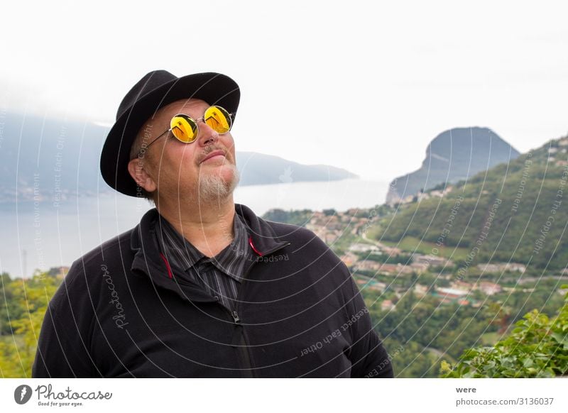 Old man in hat and sunglasses Human being To enjoy Dream bearded Granfather Lake Garda portrait Senior citizen bestager camera caucasian church church tower