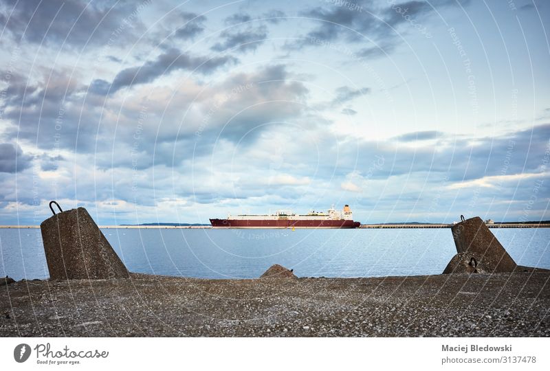 Concrete breakwater with a ship in distance at sunset. Far-off places Ocean Sky Harbour Transport Navigation Oil tanker Watercraft Maritime Protection