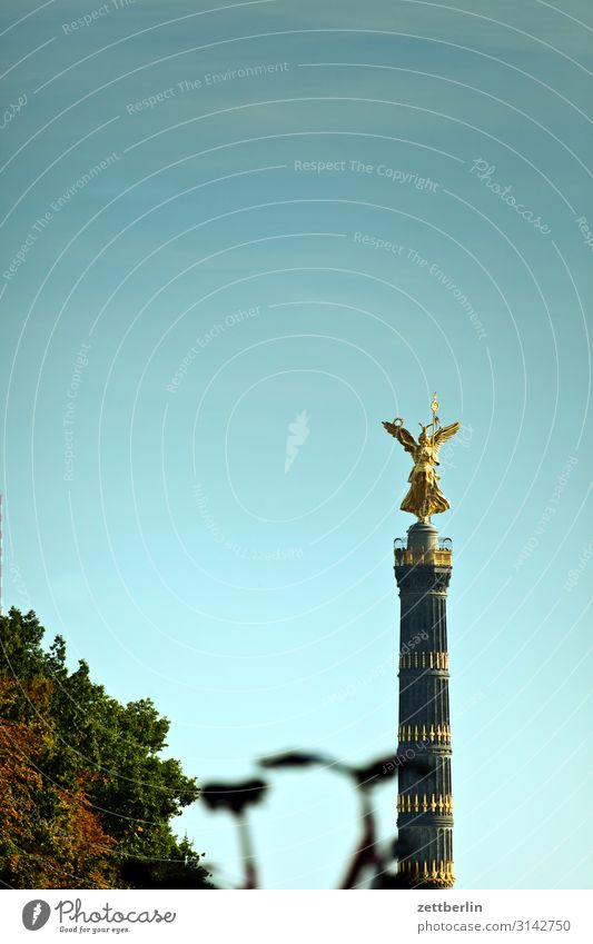 Victory column with blurred bicycle Monument else Goldelse victory statue Victoria big star Berlin zoo Park Forest Tree Downtown Berlin Germany Transport Figure