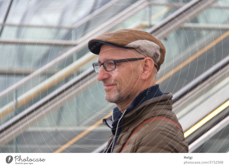 Portrait of a friendly smiling man with beard, glasses and cap Human being Masculine Man Adults 1 45 - 60 years Escalator Clothing Jacket Eyeglasses Hat