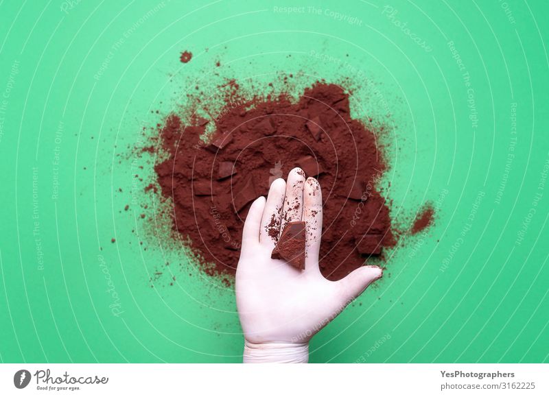Chocolate chunk in hand and cocoa pile Chocolate piece and cacao Dessert Candy Hot Chocolate Hand Brown Tradition above view background cacao powder