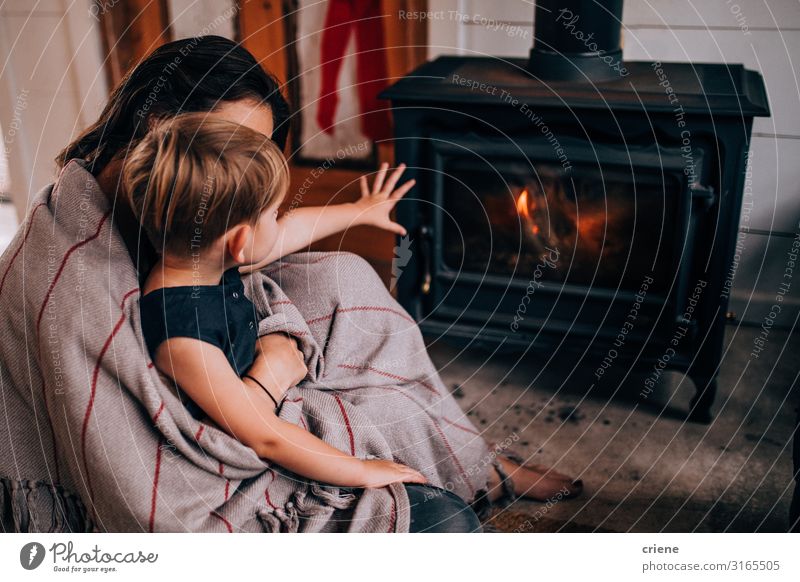 woman and toddler son sitting in front of fireplace Winter Mother Adults Family & Relations Warmth Hot Son wood flame burning Home heat stove interior room Log