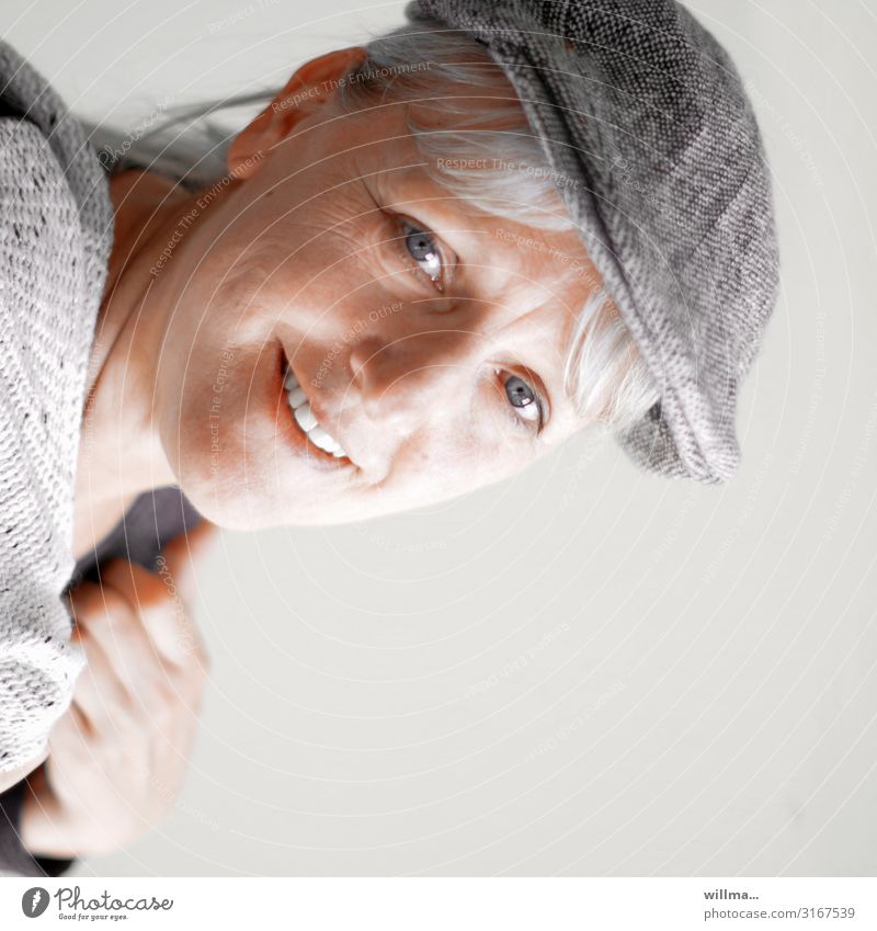 portrait of a smiling grey-haired woman with a pushcap Woman Blonde Gray-haired sliding cap Peaked cap hood Smiling Laughter Friendliness Lifestyle Easygoing