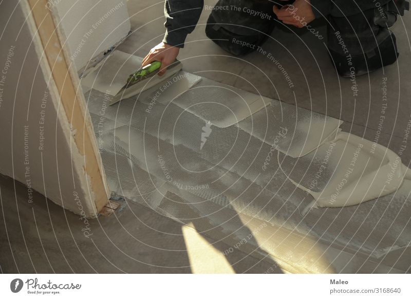 A worker installing new vinyl tile floor Man Construction site Repair House (Residential Structure) Flat (apartment) Floor covering Working man Tile Ground