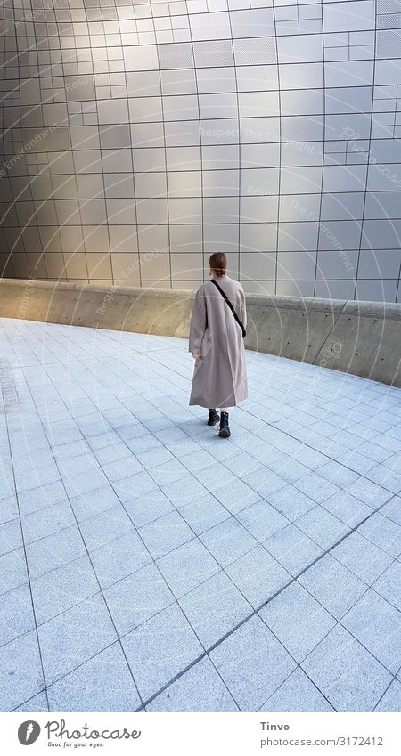 Woman in long coat walks alone across futuristic looking square Adults 1 Human being 18 - 30 years Youth (Young adults) Architecture Going Beginning End
