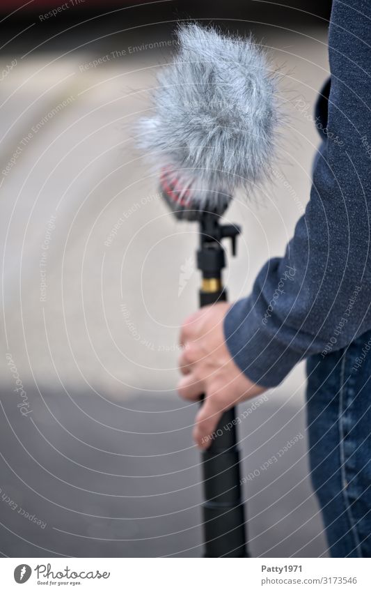 Young man holding microphone with windscreen Media industry Filming Microphone wind deflector Pelt Entertainment electronics Podcast Human being Masculine Arm