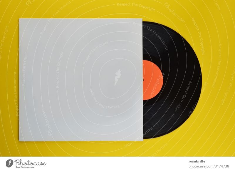 old black vinyl record half in neutral white record sleeve on yellow  background | old - a Royalty Free Stock Photo from Photocase