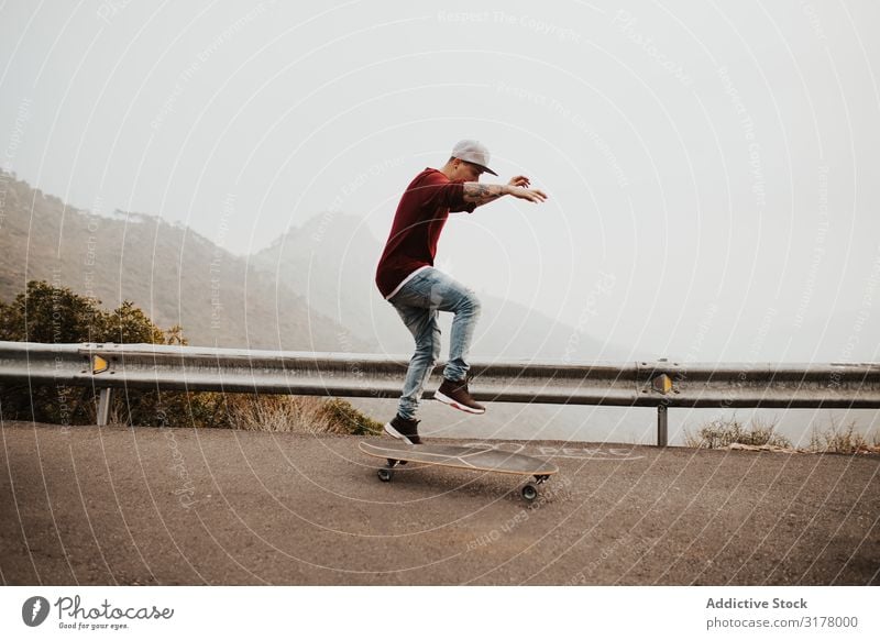 Trendy skateboarder doing trick in nature Man Skateboard Mountain Trick Street Ride Longboard Jump Fog Landscape Remote Panorama (Format) Skateboarding Practice