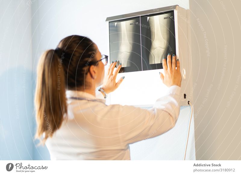 Young doctor with x-ray film document on wall Doctor Medication Radiology Uniform Film Image Wall (building) Room Woman Looking Youth (Young adults) radiography