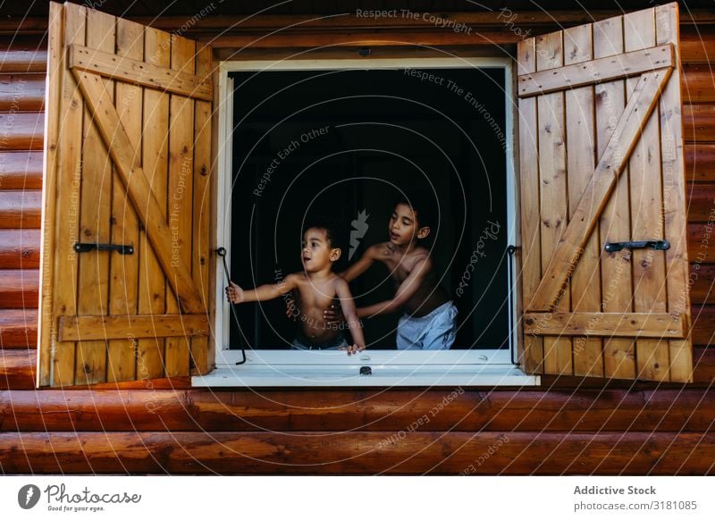 Black boys looking out window brothers Window House (Residential Structure) Wood Open Joy Together African-American Child Boy (child) siblings shirtless Shutter