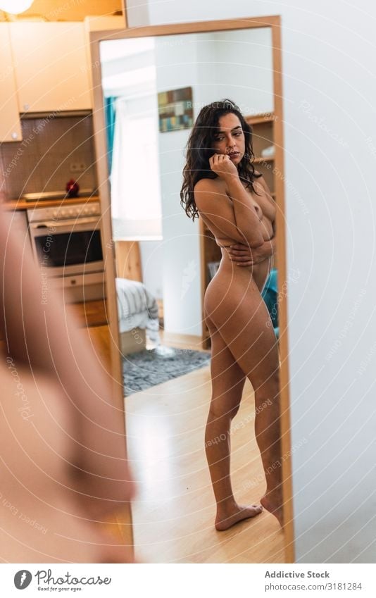 Naked woman looking at mirror - a Royalty Free Stock Photo from