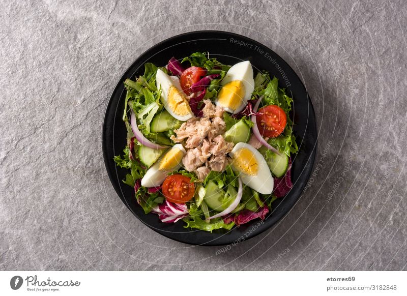 Salad with tuna, egg and vegetables on black plate Vegetable Tuna fish Egg Tomato Lettuce Black Plate Onion Cucumber Slice Mixed Olive oil Healthy Eating Food