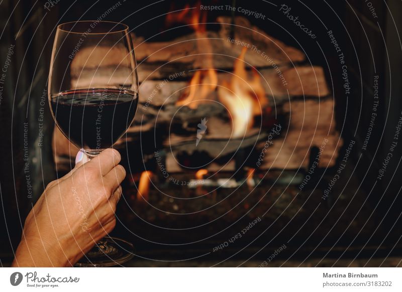 A glass of red wine in front of a burning fire place Alcoholic drinks Lifestyle Relaxation Leisure and hobbies Winter House (Residential Structure)