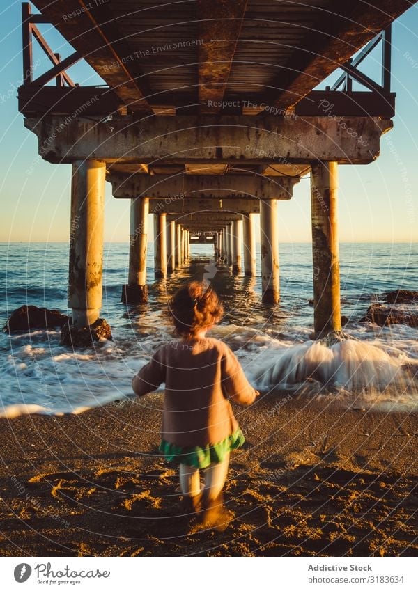 back view of kid under a pier Rear view Girl Child Walking Jetty Sunset Nature Ocean Beach Background picture Sky Water Vacation & Travel Landscape Blue peer