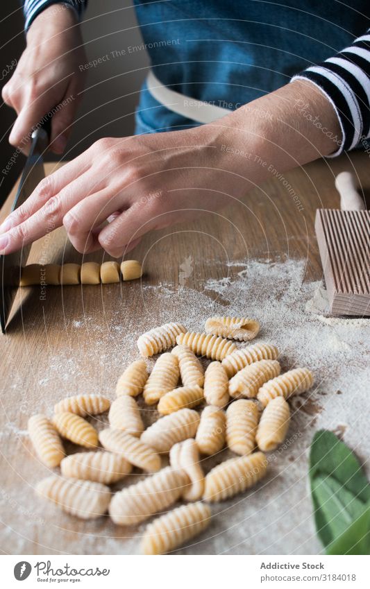 Crop woman making gnocchetti pasta Woman Pasta cutting Dough Preparation Italian Table Kitchen Home-made Tradition Raw Food Cooking recipe Ingredients Fresh