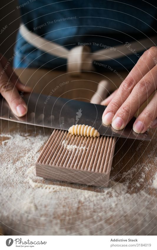 Crop woman making gnocchetti pasta Woman Pasta cutting Dough Preparation Italian Table Kitchen Home-made Tradition Raw Food wood tool Cooking recipe Ingredients