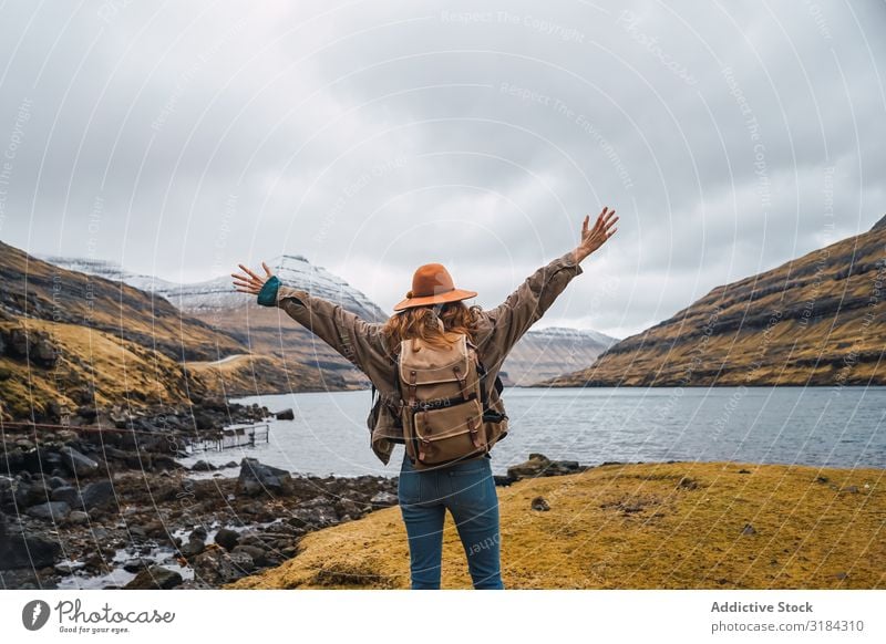 Back view of woman traveler stretching out arms Woman outstretched arms Anonymous Cliff Ocean Excitement Føroyar Sky Gray Clouds Action Happy Cheerful Hipster