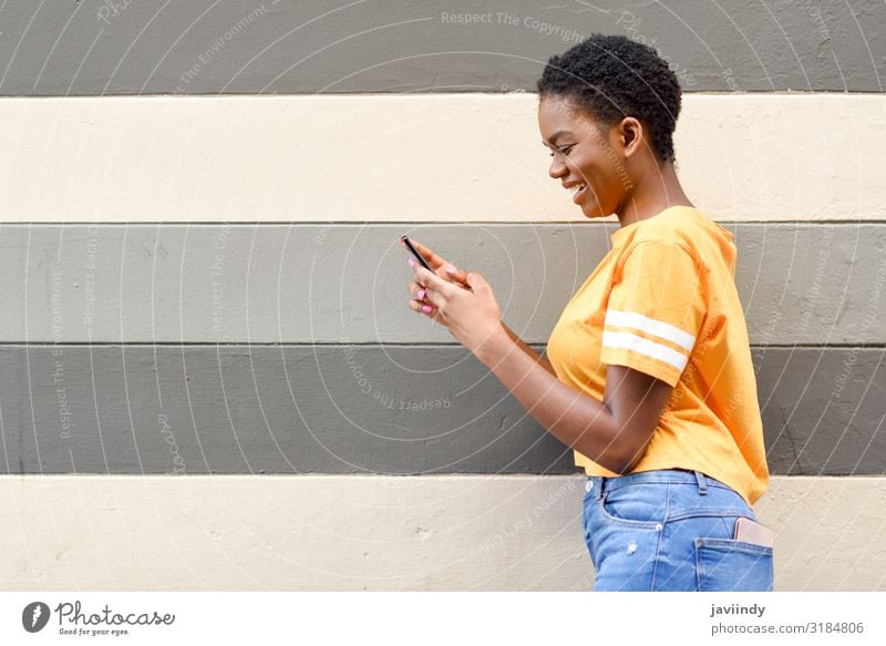 Young black woman laughing using her smart phone outdoors. Lifestyle Style Joy Happy Hair and hairstyles Telephone Cellphone PDA Technology Internet Human being