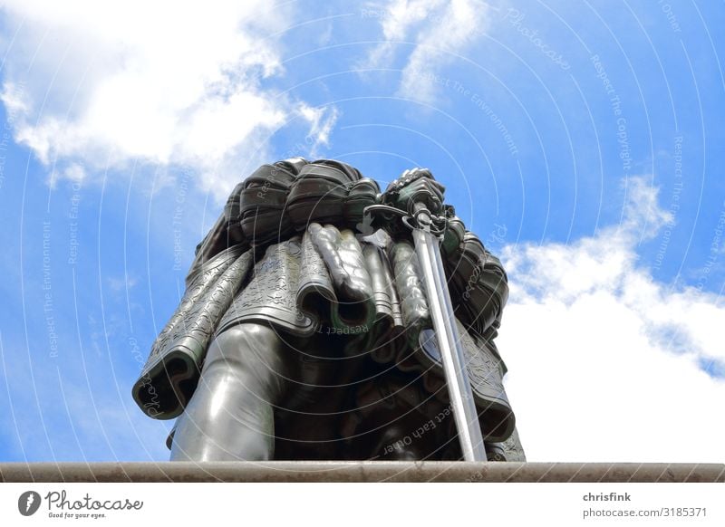 Statue with sword from below against blue sky 1 Human being Art Sculpture Town Downtown Castle Marketplace Manmade structures Aggression Esthetic Athletic