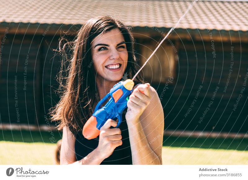 Young woman shooting and splashing with water gun Woman Splashing Water Youth (Young adults) Aim water-pistol Happy Joy Summer Beautiful Playing Party Wet Girl
