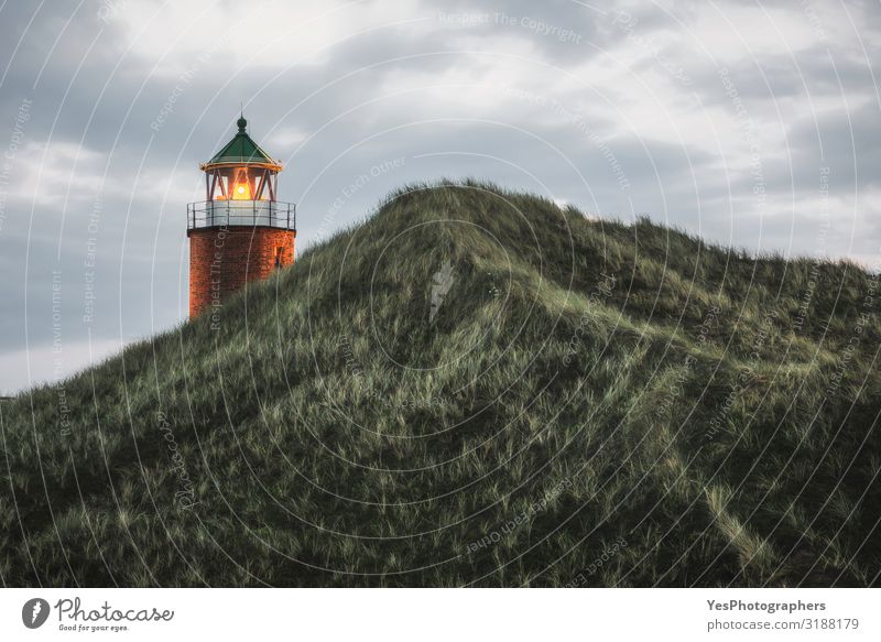 Lit lighthouse on a hill with tall grass and moss on Sylt island Vacation & Travel Summer Summer vacation Environment Nature Landscape Sky Climate Weather Wind