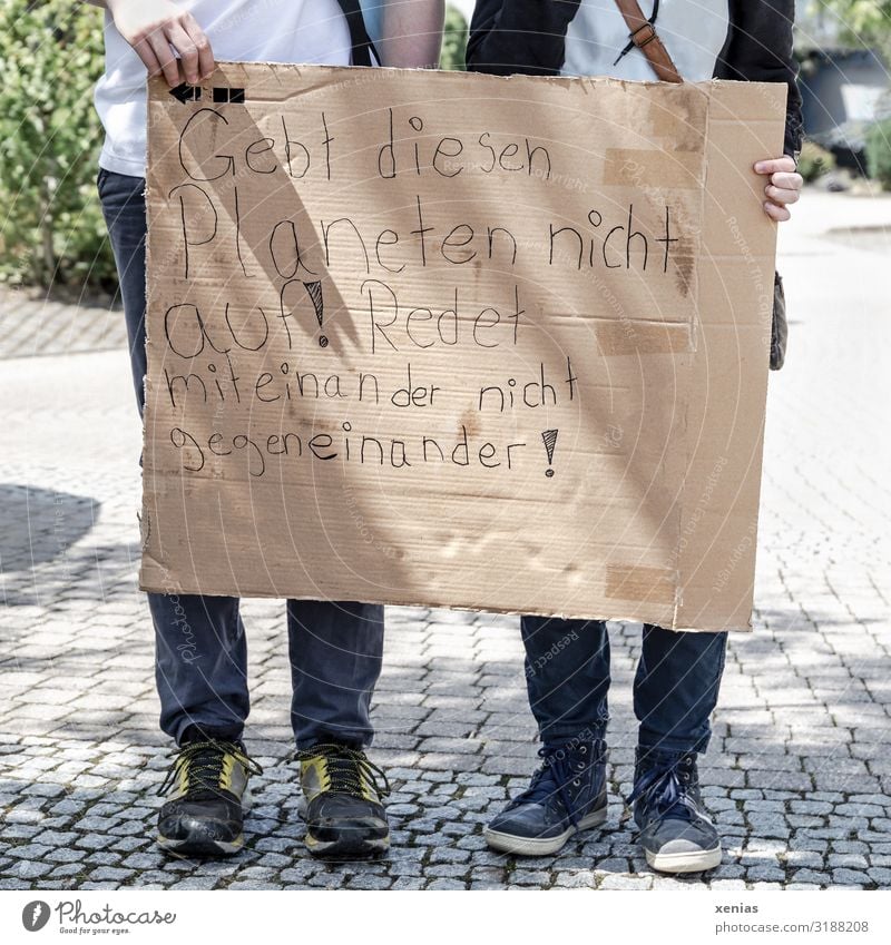 Weltschmerz / two teenagers stand on the street and hold labeled cardboard in their hands for fridays for future - Demonstration - Don't give up on this planet! Do not talk to each other against each other!
