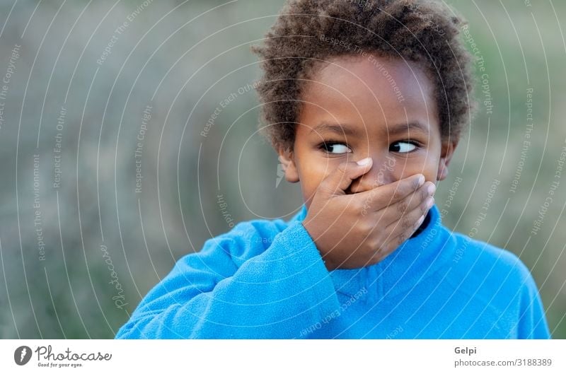 Little african boy covering his mouth with a blue jersey Happy Beautiful Face Calm Child Schoolchild Human being Boy (child) Man Adults Infancy Mouth Lips Hand