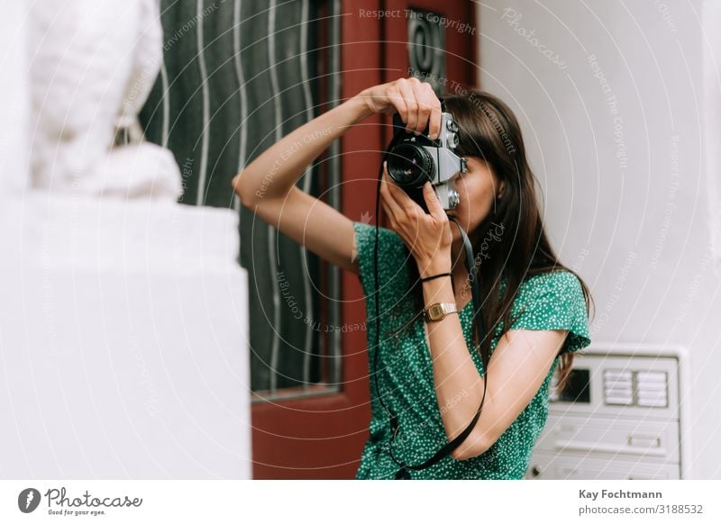 elegant woman wearing a green dress is taking a picture with an old film camera activity analog beauty capturing caucasian discovering elegance european explore