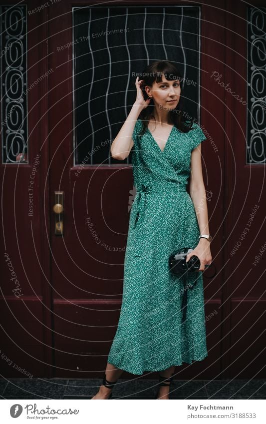 elegant woman wearing a green dress is holding an old film camera in her hands activity analog beauty capturing caucasian discovering elegance european explore