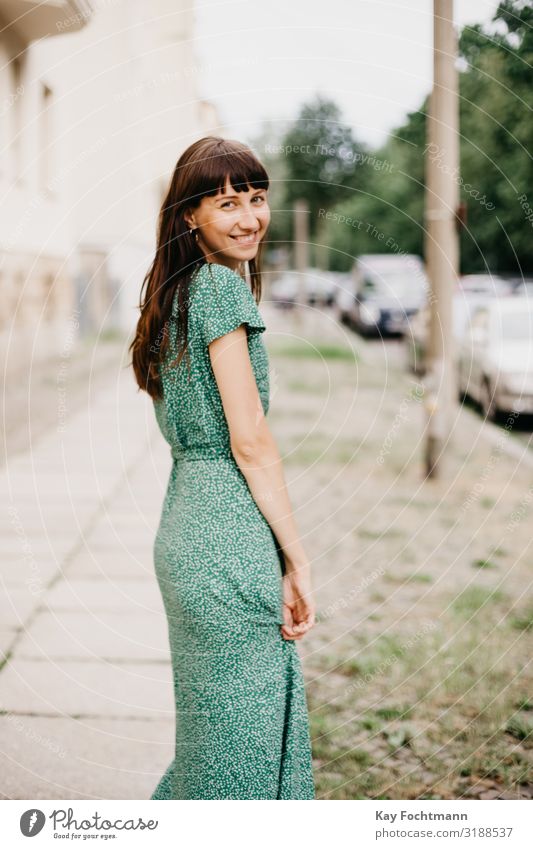 woman wearing an elegant green dress is turning around to smile at camera adult attractive beautiful woman charming chic city classic clothing confident europe