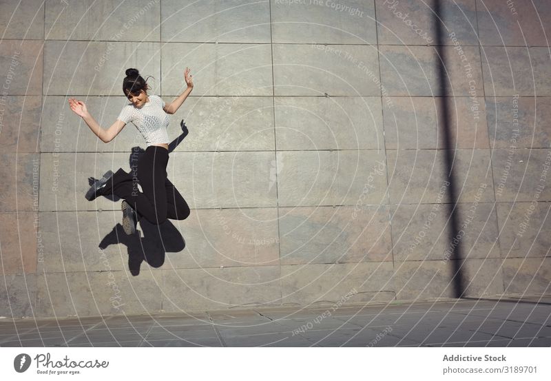 Girl jumping happily in the streets. Adults American Background picture Beautiful Easygoing Cheerful City Conceptual design Woman Freedom Friendship Joy