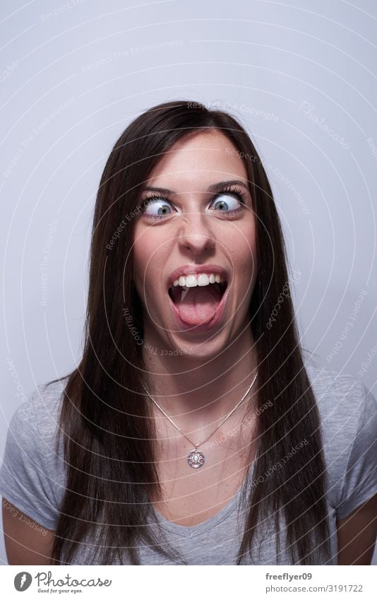 Portrait of a crossed eye woman making silly faces Joy Beautiful Face Human being Woman Adults T-shirt Brunette Long-haired Laughter Funny Blue Gray White