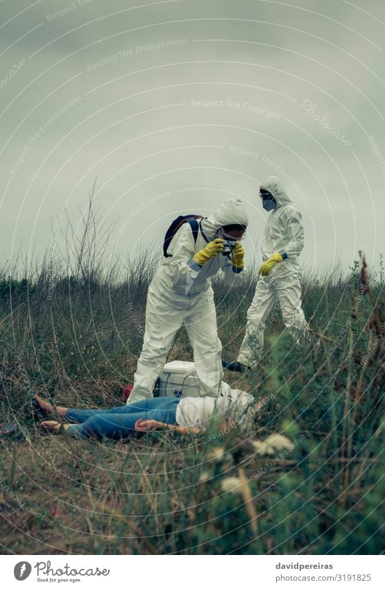 Man and woman in protective suit taking a photo of a corpse Body Camera Human being Woman Adults Protection Death Dangerous Take Illustration Corpse Epidemic