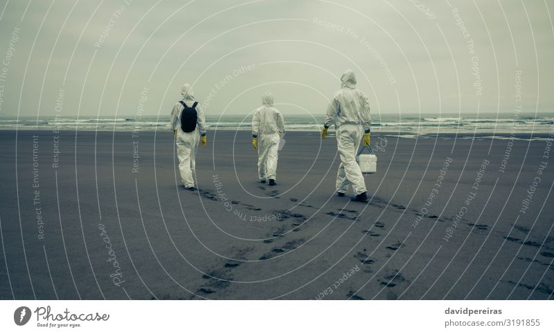 People with protection suits walking on the beach Beach Ocean Waves Human being Woman Adults Man Sand Coast Gloves Footprint Protection Crisis Unrecognizable