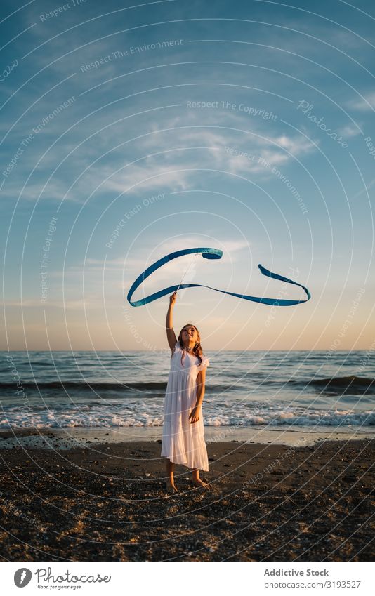 Adorable girl playing with ribbon on seaside Girl Playing Delightful String Coast Running Band Evening Beach having fun Summer Water Ocean Child Infancy