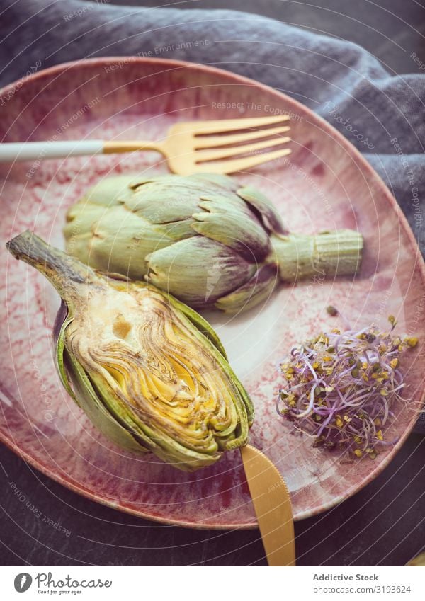 Knife fork and artichokes on plate Artichoke Knives Fork Plate Cut whole Table Food Cooking Organic Healthy Fresh Diet Nutrition Vegan diet Vegetarian diet