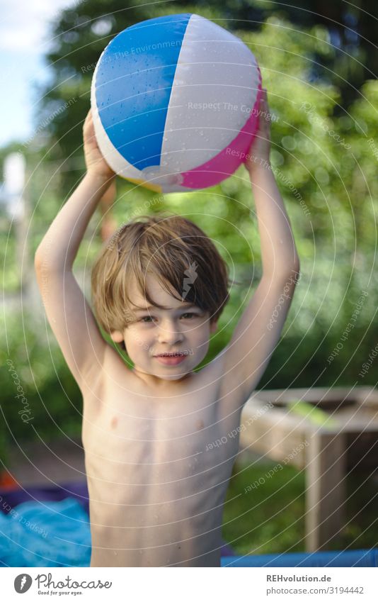 Child holds a water polo ball in the garden Ball Beach ball Garden Wet Boy (child) Infancy fortunate luck Joy Summer warm stop Throw Playing variegated