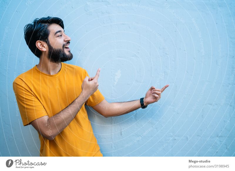 Portrait of young man showing something. Happy Beautiful Human being Man Adults Hand Smiling Stand Self-confident Advertising space copy background people