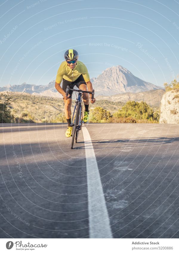 healthy man riding a bicycle on a mountain road in a sunny day Leisure and hobbies Athlete Sports Ride Bicycle Racing sports Man Motorcycling Exterior shot