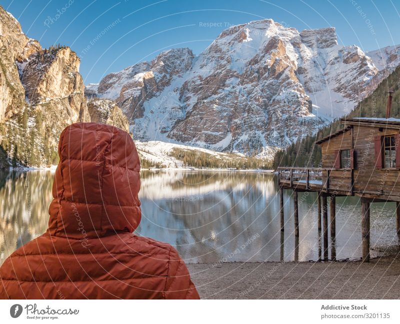 Unrecognizable person in warm jacket standing and looking at serene landscape Human being Landscape Serene Reflection Break water Nature Ocean Rock Coast Water