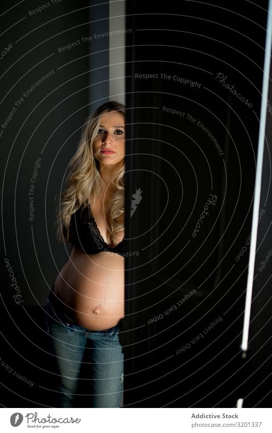 Pregnant lady near open door Woman To enjoy Door Open Home Bra Showing one's bellybutton Light expecting tummy Stomach Abdomen maternity awaiting Anticipation